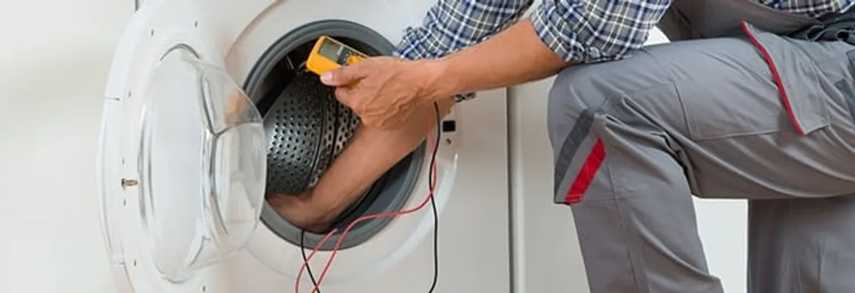 Dryer repair technician inspecting and repairing a clothes dryer in Atlanta, GA