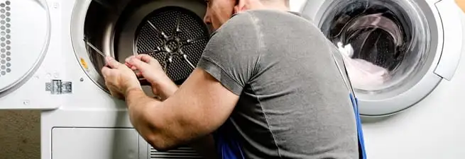 Dryer repair technician fixing a clothes dryer drum in Atlanta, GA