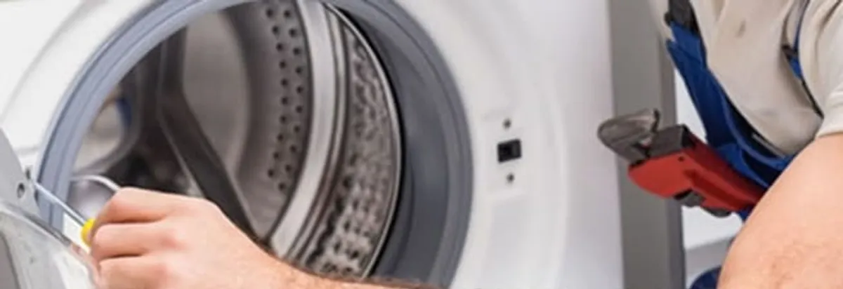 Appliance technician repairing a clothes dryer drum and internal parts in Atlanta, GA