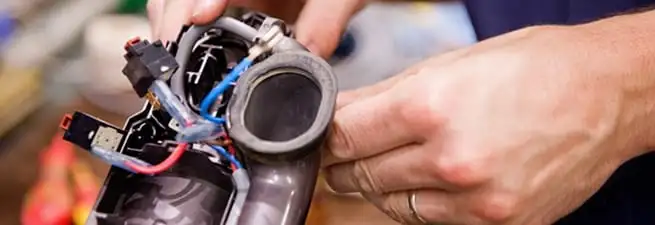 Vacuum repair technician reconnecting wiring and components in Atlanta, GA
