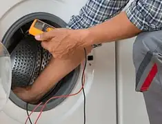 Washing machine repair technician testing a front-load washer with diagnostic tools in Atlanta, GA