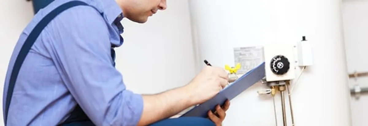 Water heater repair technician inspecting the unit and recording service notes in Atlanta, GA